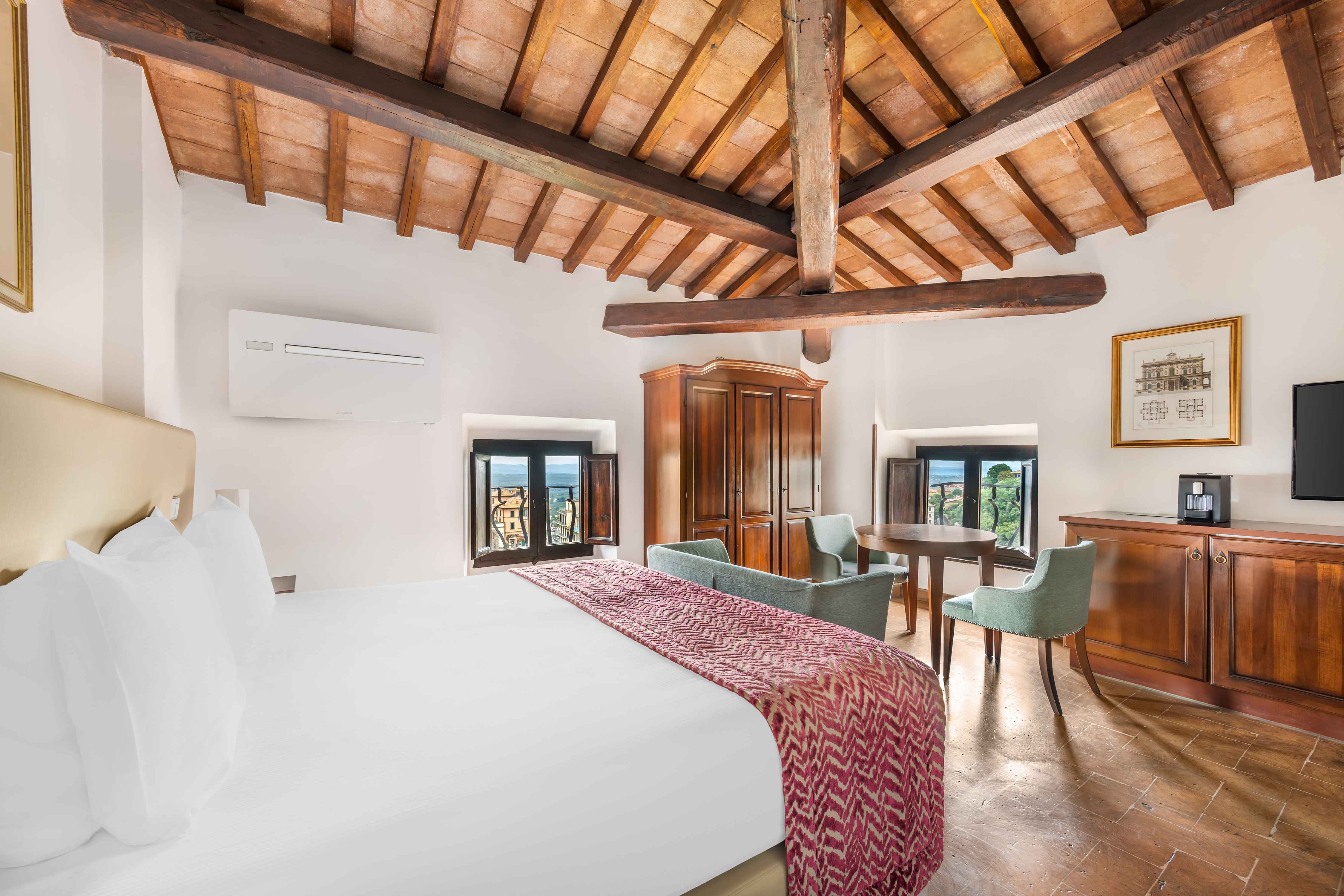 image Sleep beneath exposed beams in a cozy lofted bedroom that captures rustic Italian charm.