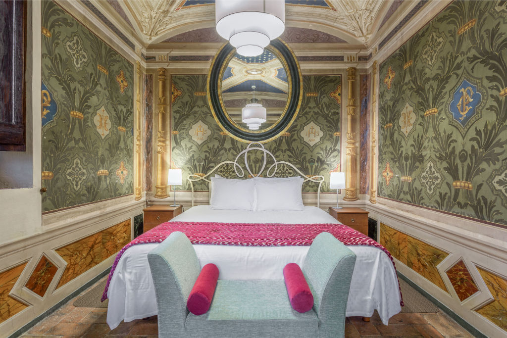 image Wake up under a frescoed ceiling in a bedroom that marries historic artistry with contemporary comfort.