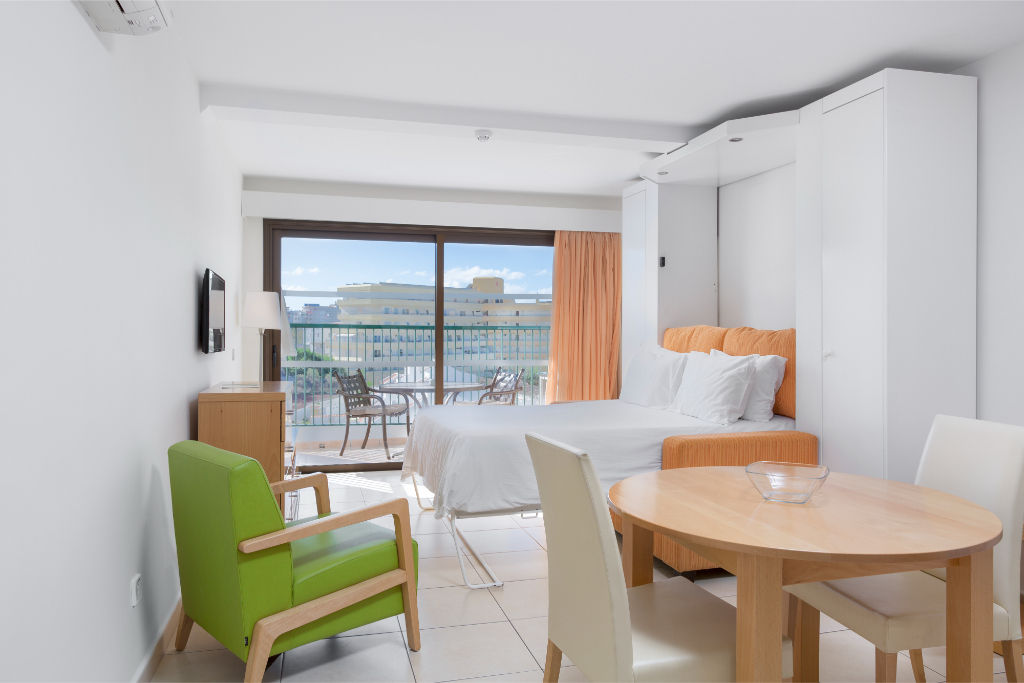 image Compact dining and living area with natural light, suitable for meals or studying.