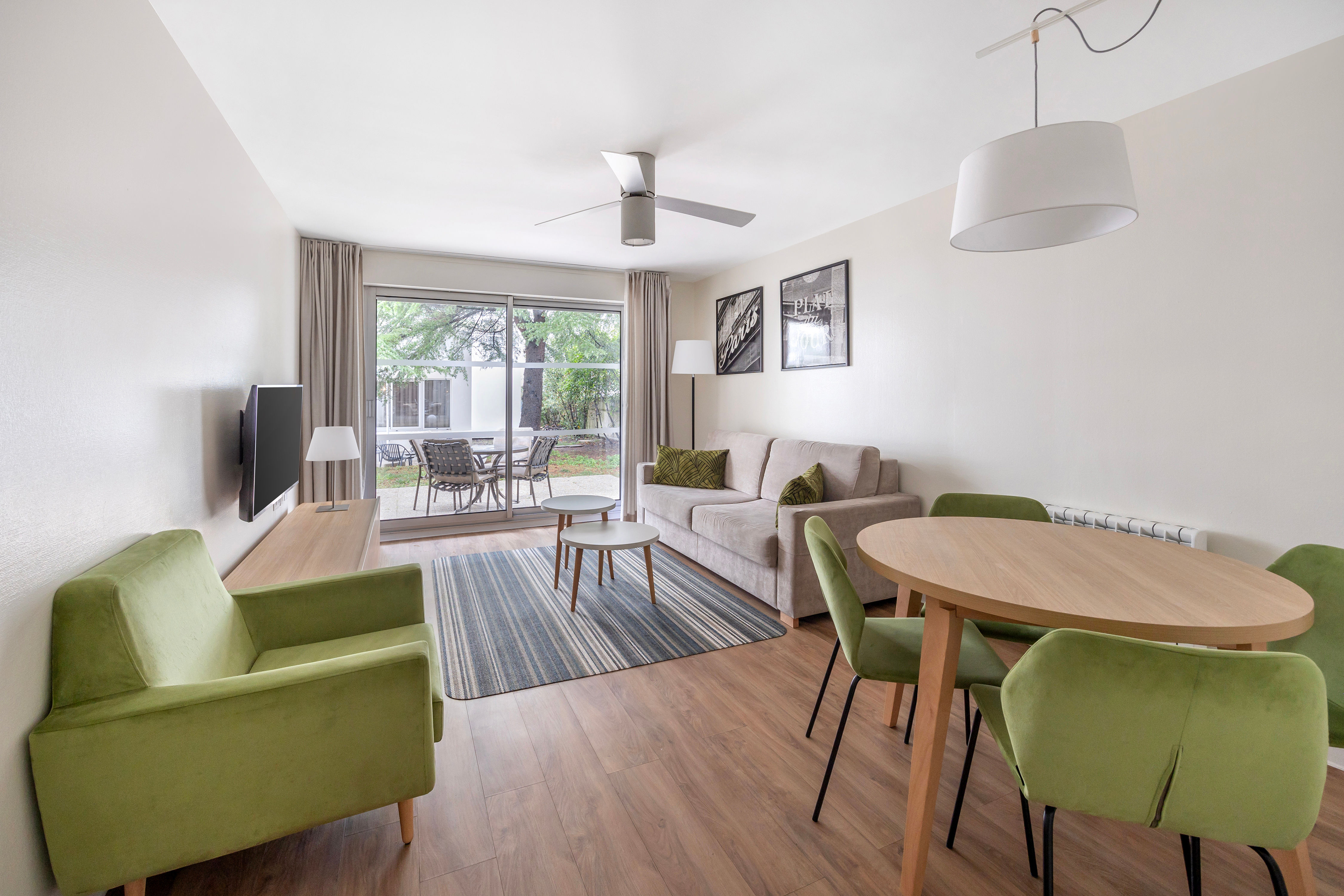 image Spacious living room with a cosy sofa, flat-screen TV, and dining area, ideal for entertaining or relaxing.