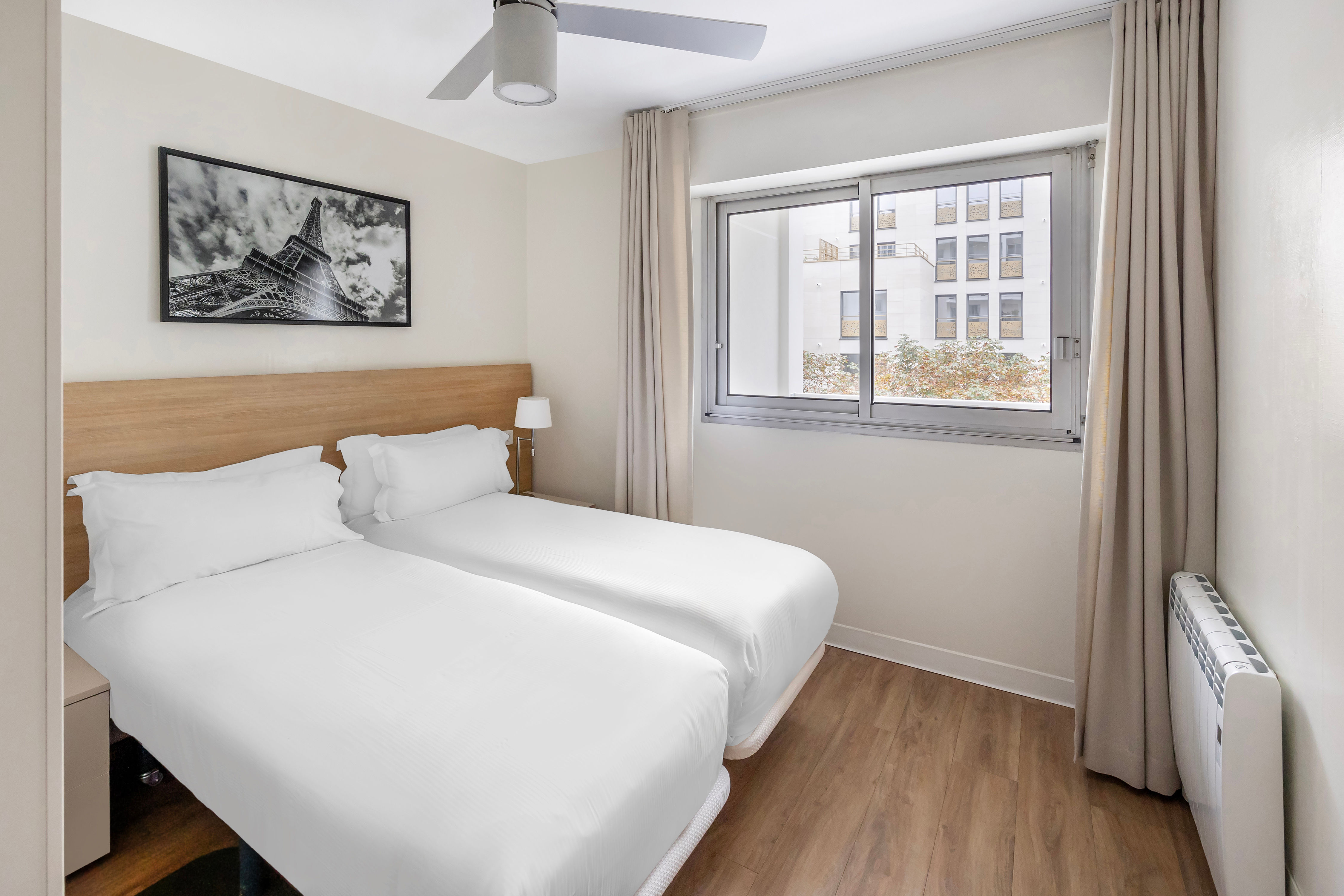 image A cosy guest bedroom with two single beds, perfect for friends or family, offering ample natural light and a peaceful ambience.