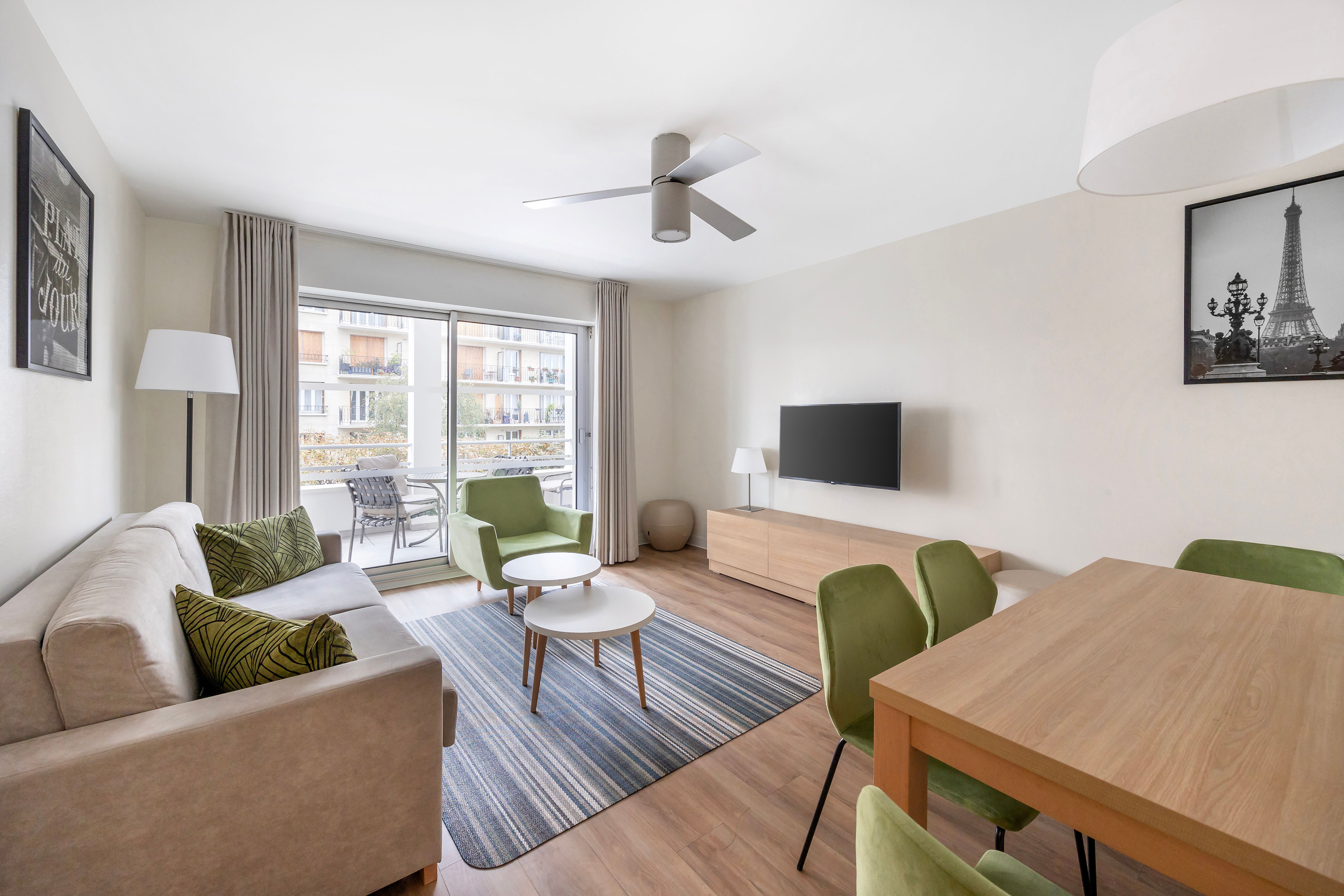 image Bright and spacious living room with comfortable seating, a smart TV, and access to the private balcony for relaxation after a busy day.