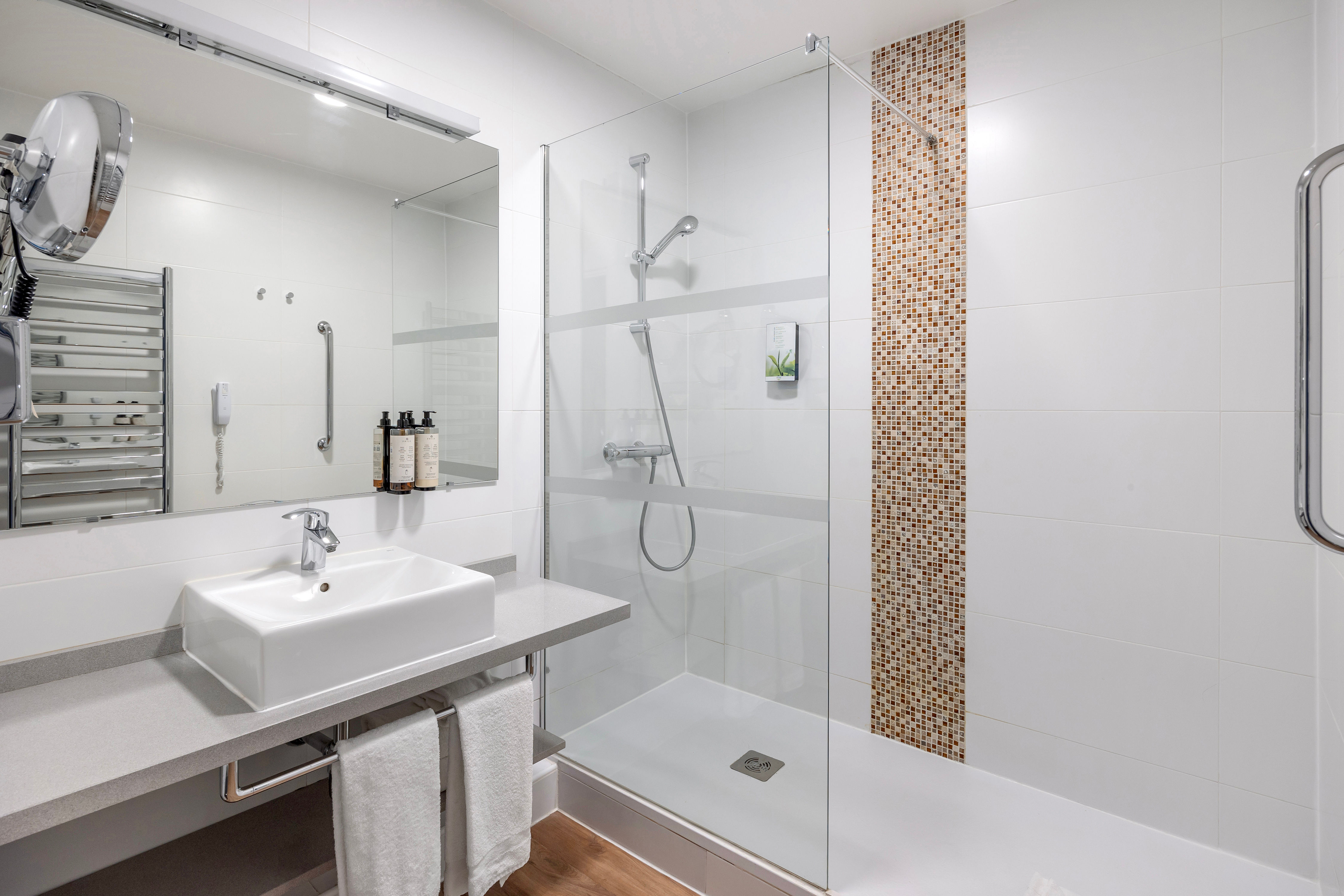 image Modern bathroom featuring a sleek walk-in shower, heated towel rail, and complimentary toiletries for your comfort.