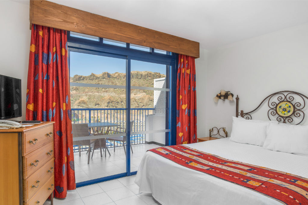 image Wake up to stunning mountain views in this cozy, ski-themed bedroom.