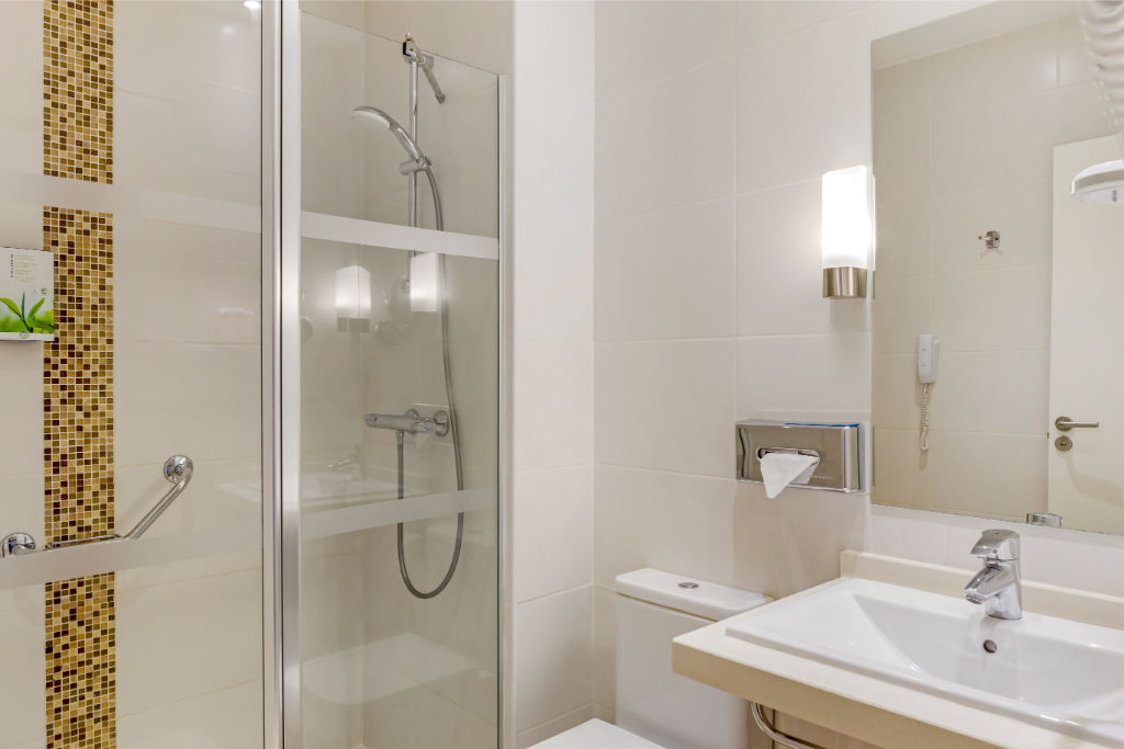 image Compact and efficient bathroom with clean lines and a glass shower enclosure.