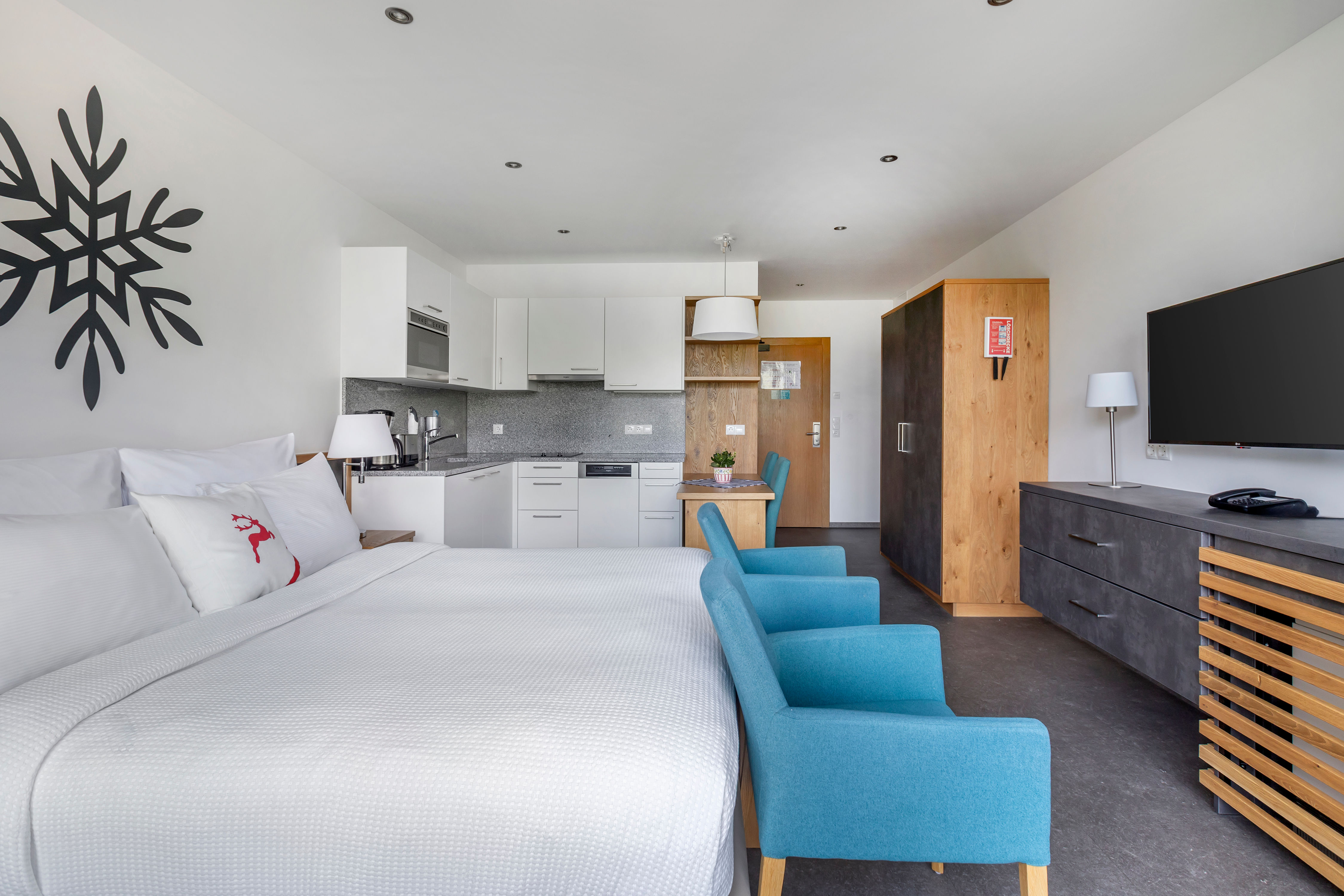 image Bright studio apartment with cozy bedding, smart TV, and open-plan kitchenette – perfect for relaxing after a day on the pistes.
