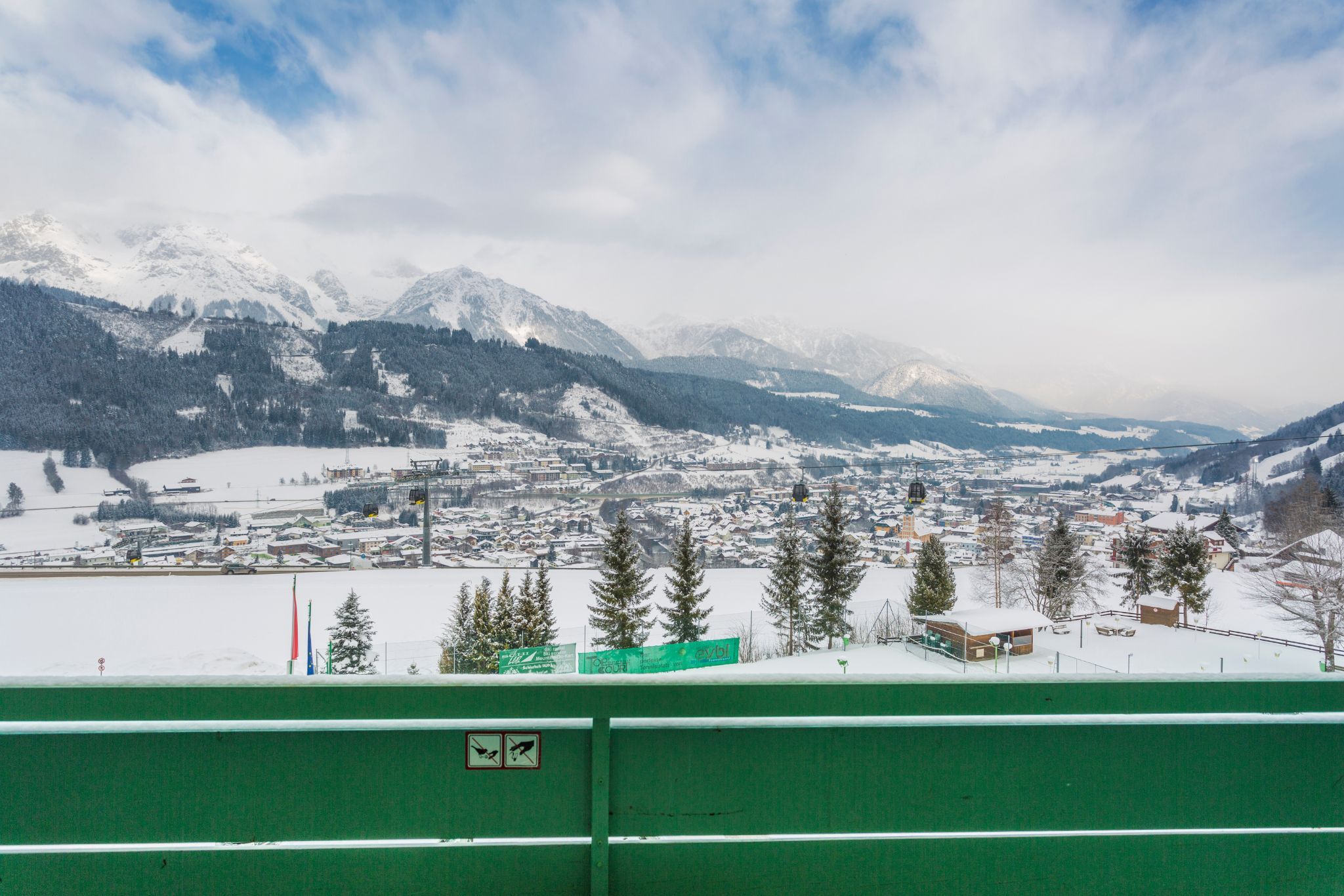 image A stunning vista unfolds from the patio, revealing a snow-covered village nestled beneath majestic mountains, providing a picturesque backdrop all year round.