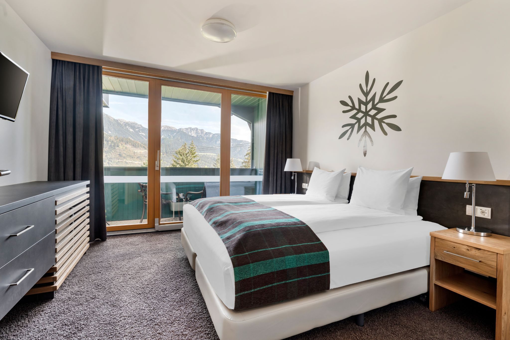 image With breathtaking mountain views visible from its balcony, this stylish bedroom includes a comfortable double bed and a smart TV for entertaining guests.