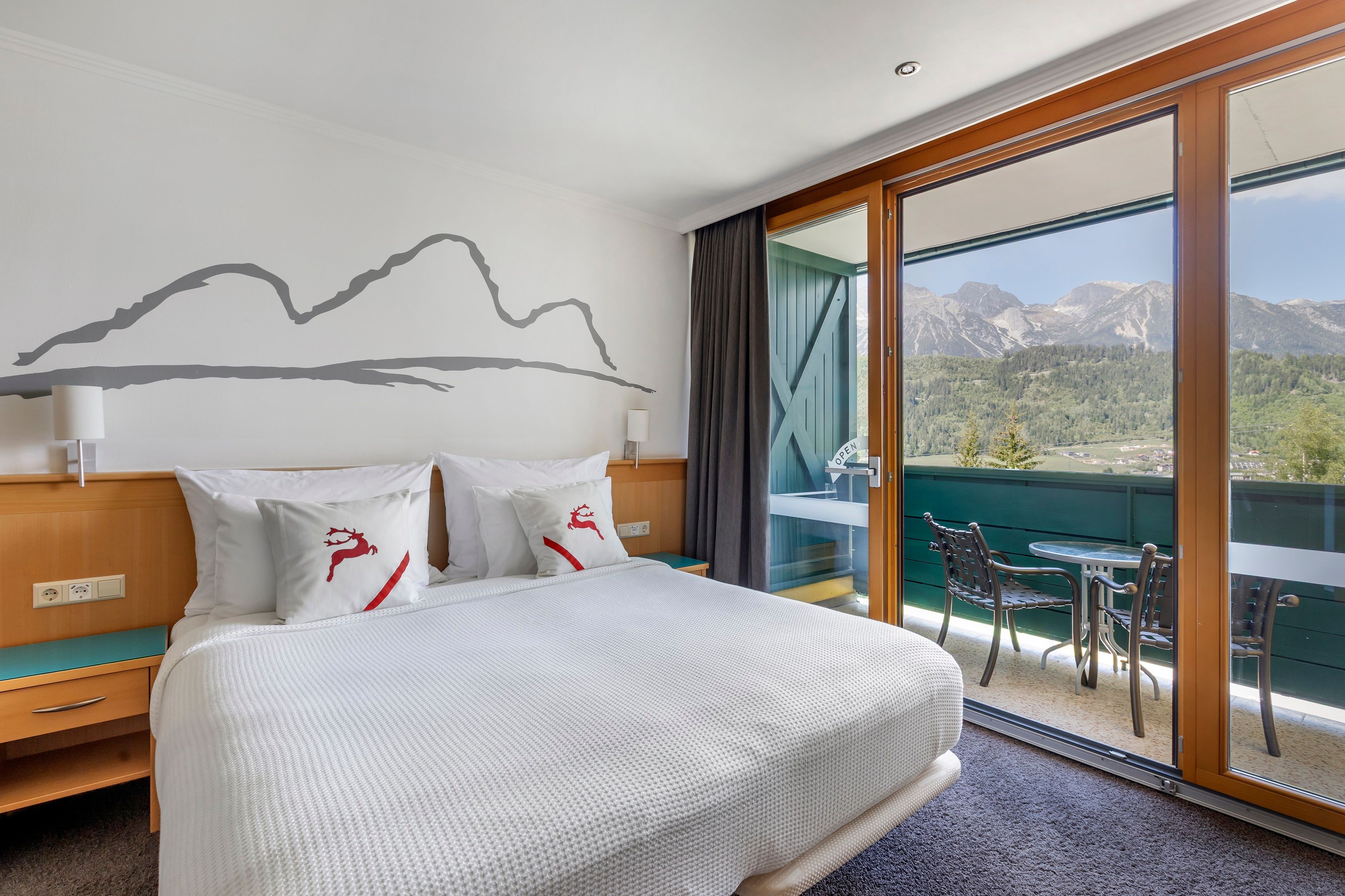 image Bright, alpine-style bedroom with direct balcony access and panoramic mountain views – perfect for a peaceful morning coffee or evening unwind.