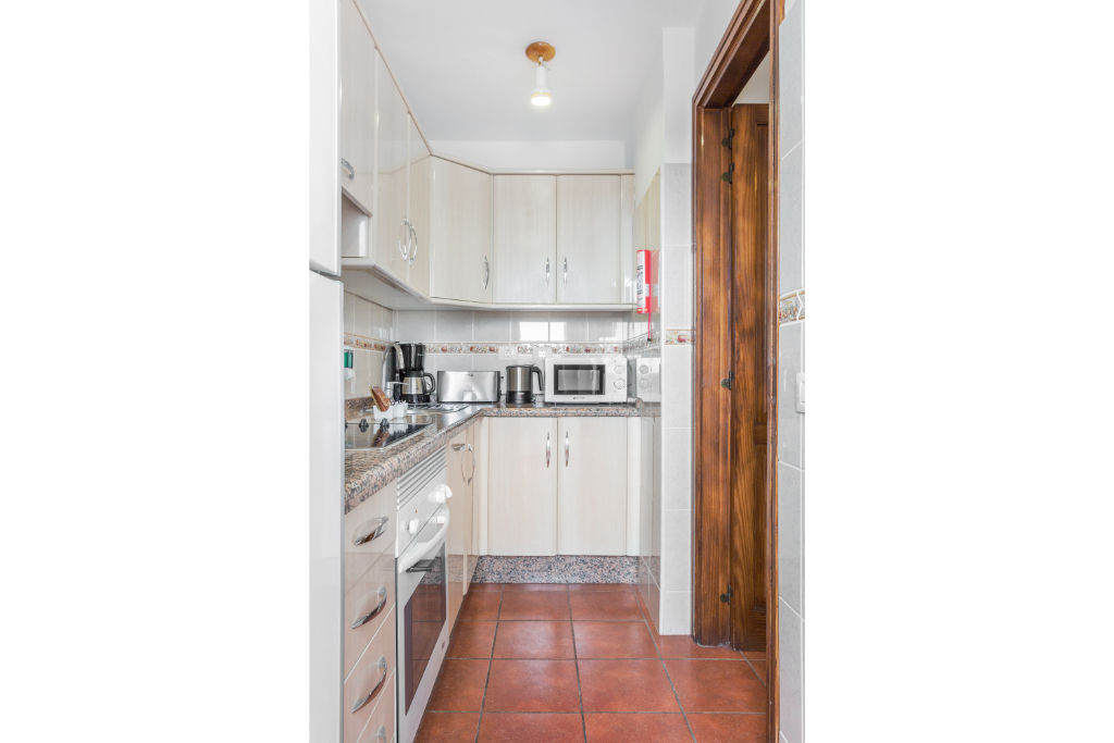 image Streamlined kitchen space, complete with modern amenities for convenient meal prep.