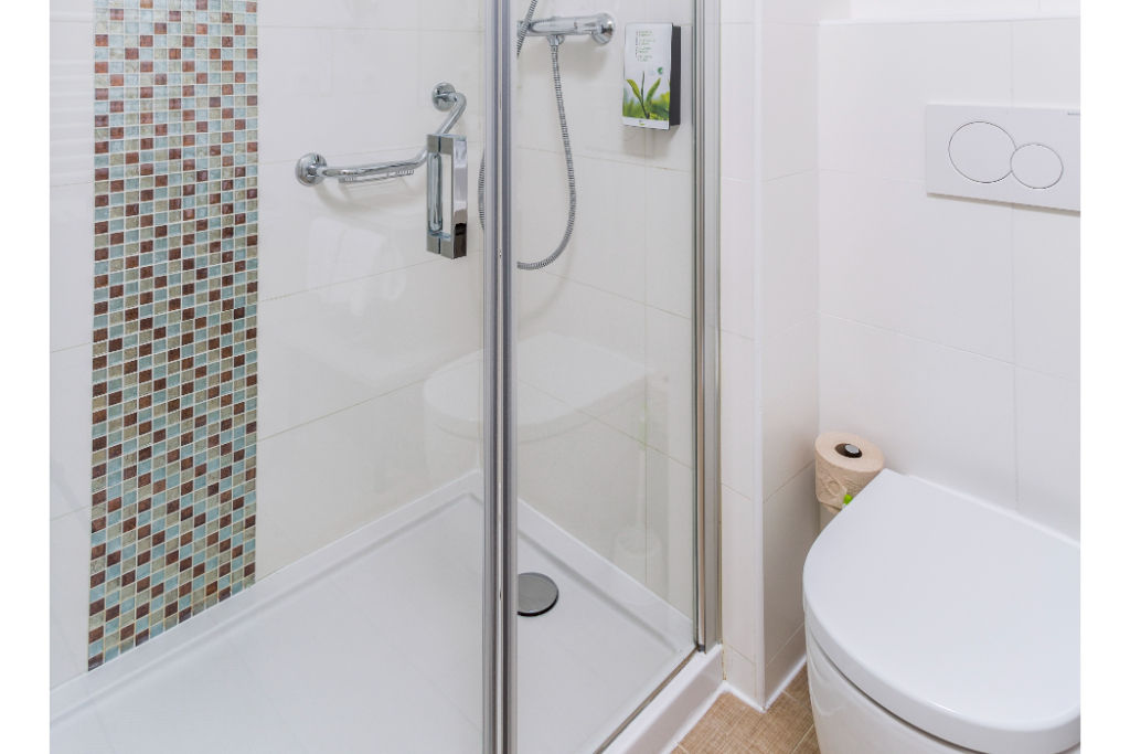 image Compact and clean bathroom with a glass shower, offering functionality in a stylish space.