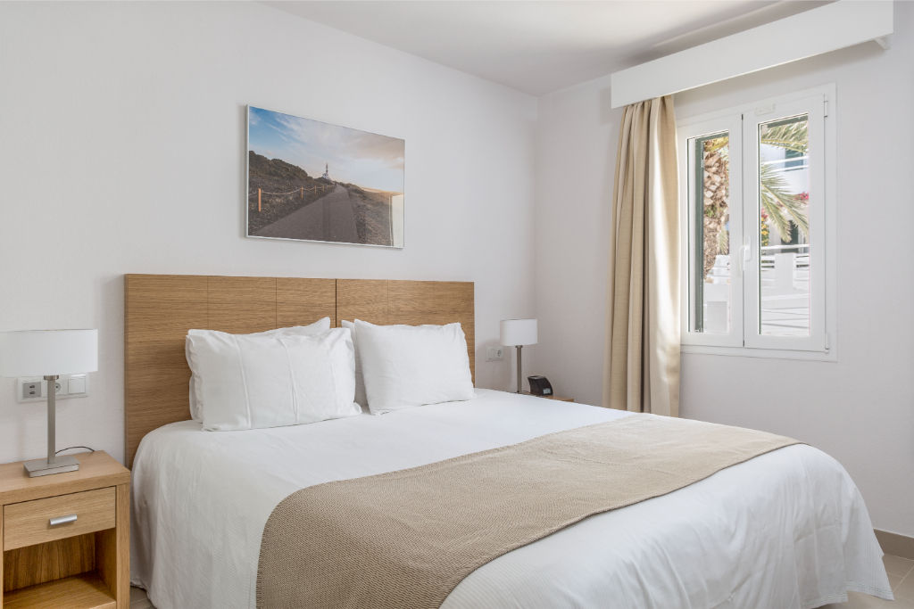 image Bright bedroom with a comfortable bed and crisp white linens.