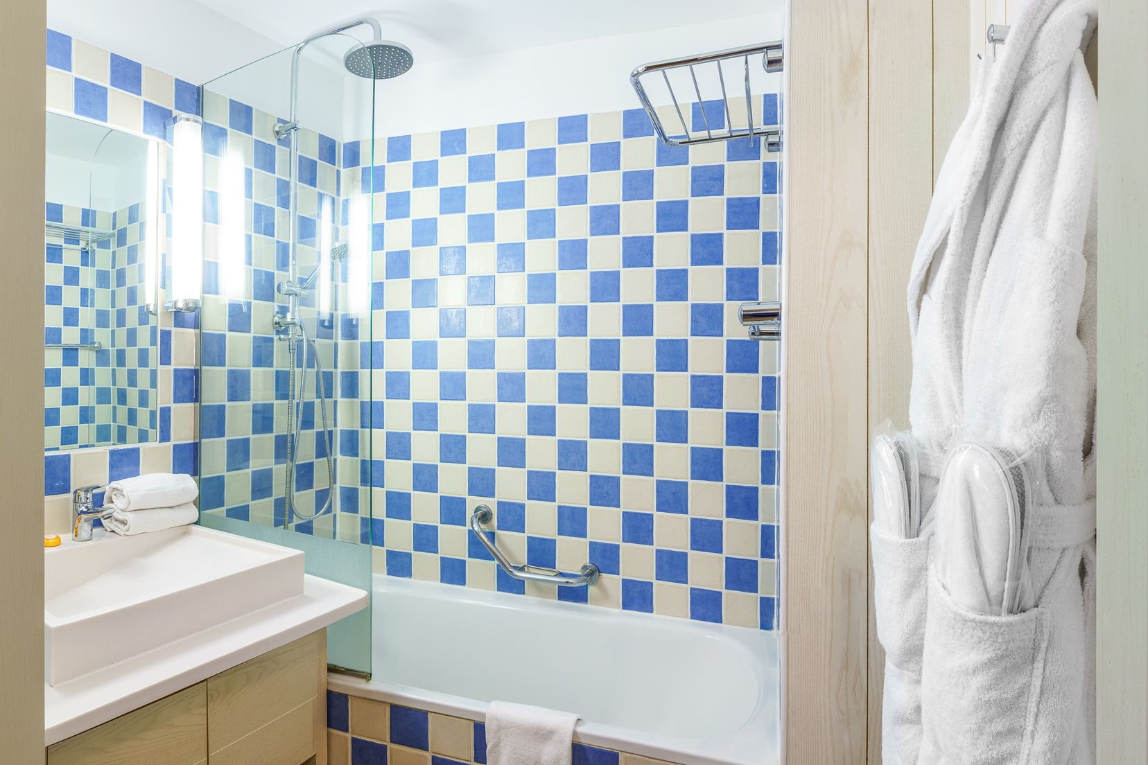 image Bathtub with shower, sink and tiled walls