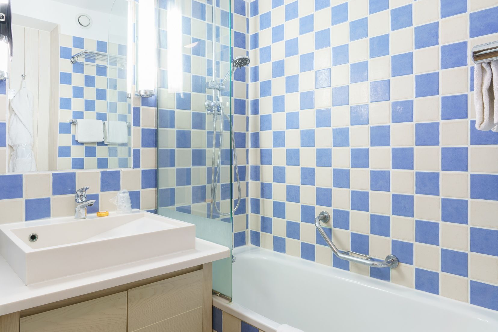 image Tiled bathroom with sink and bathtub with shower