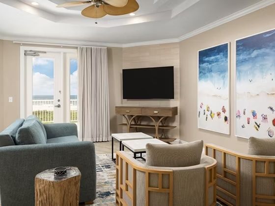 image Teal sofa and accent artwork in the open living area — free Wi-Fi and cable TV included