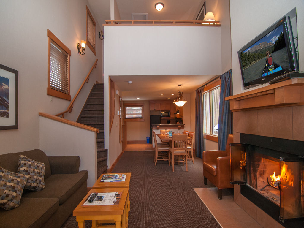 image Enjoy the warm ambiance of this loft-style living room, complete with a cozy fireplace and inviting decor.