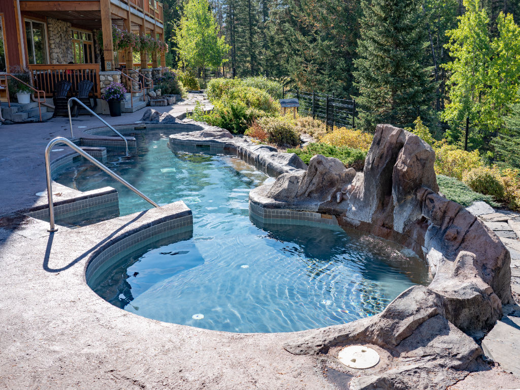 image Relax in the serene outdoor hot tub, surrounded by lush greenery and scenic mountain views.