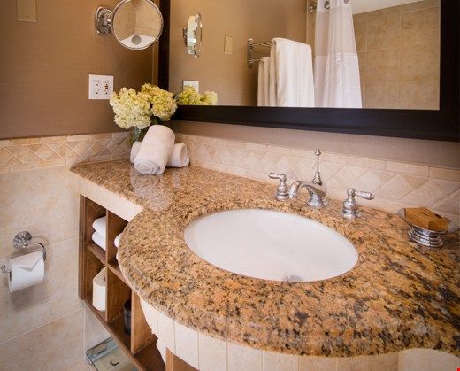 image The modern bathroom features pristine granite countertops and marble floors, and comes equipped with plush bathrobes and slippers.