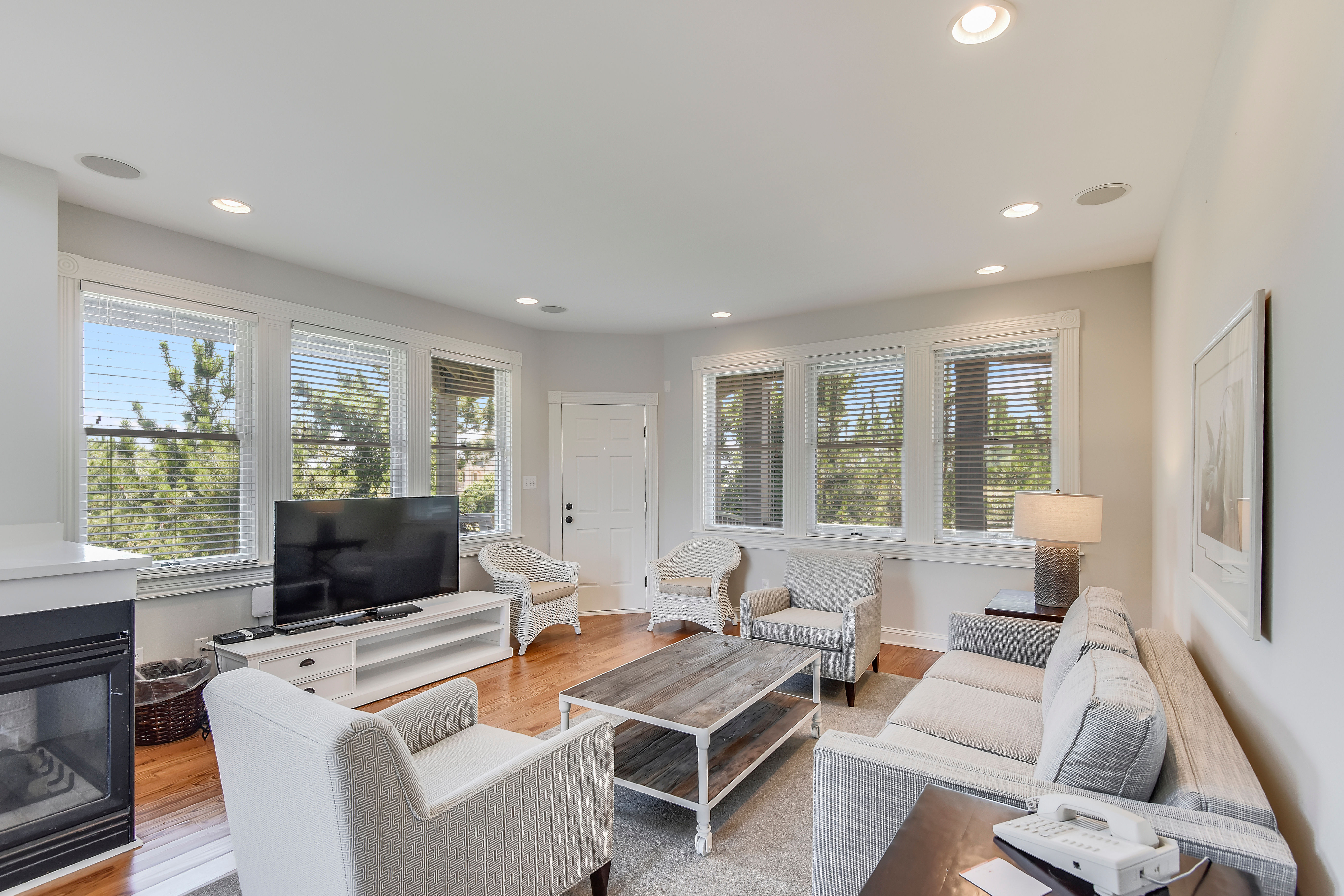 image Gather with ease in a sunlit living room where crisp tones, soft textures, and surrounding views create the perfect coastal retreat.