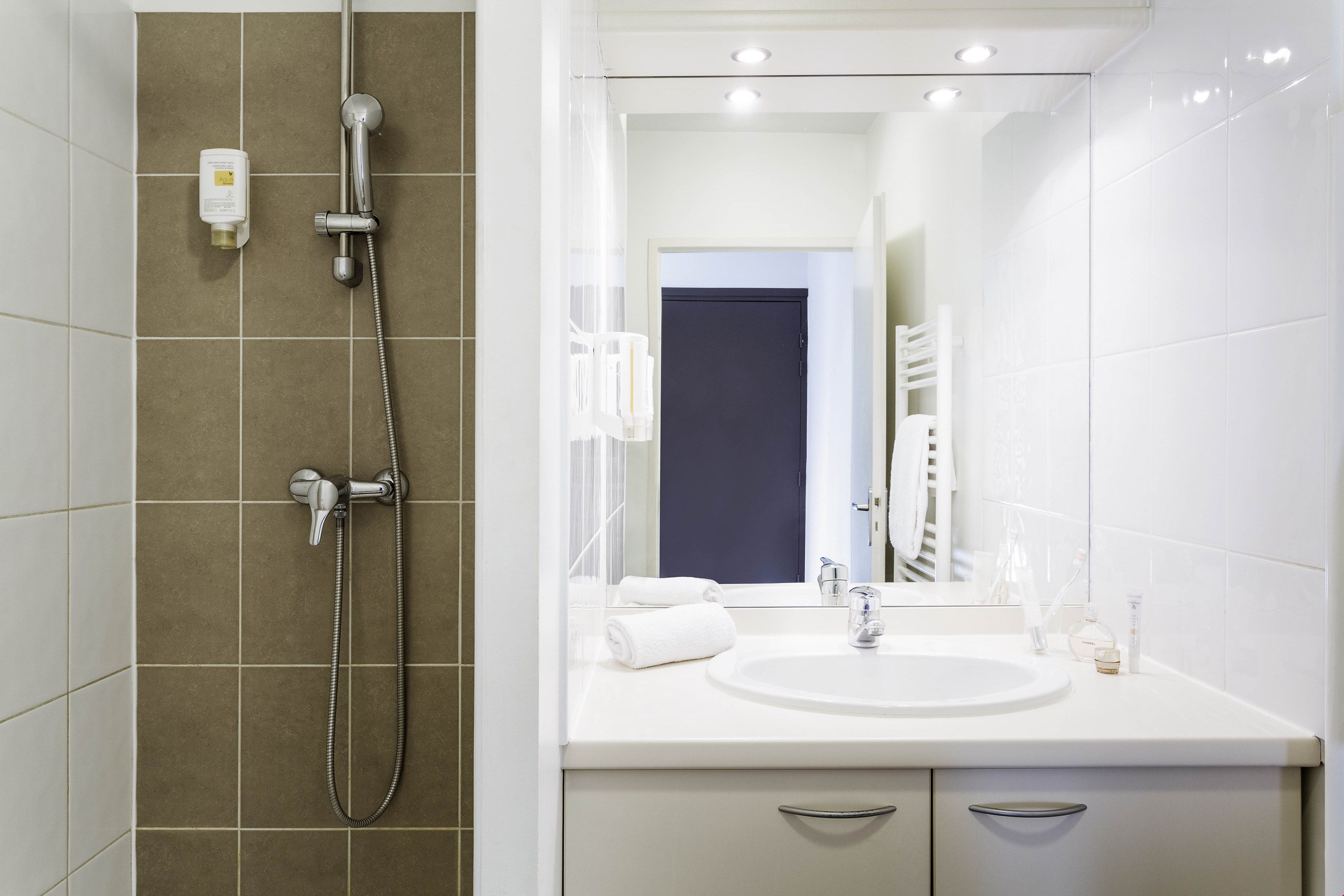 image The modern and full bathroom features a shower and a towel dryer