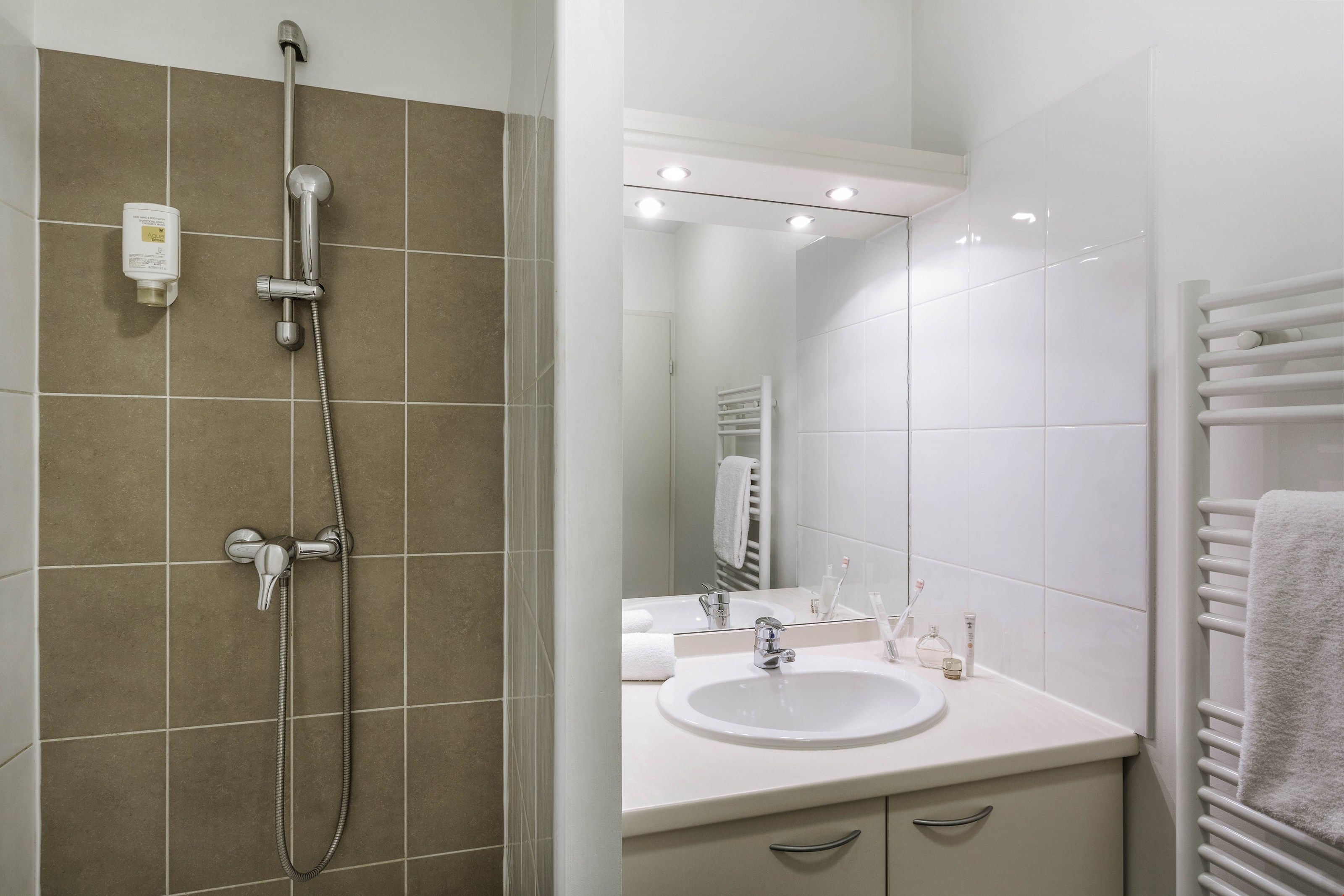 image The modern and full bathroom features a shower and a towel dryer