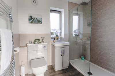 The bathroom features a towel rail and heated flooring.