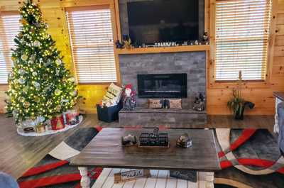  Inviting living area with a cozy fireplace, glowing with natural light and holiday charm.