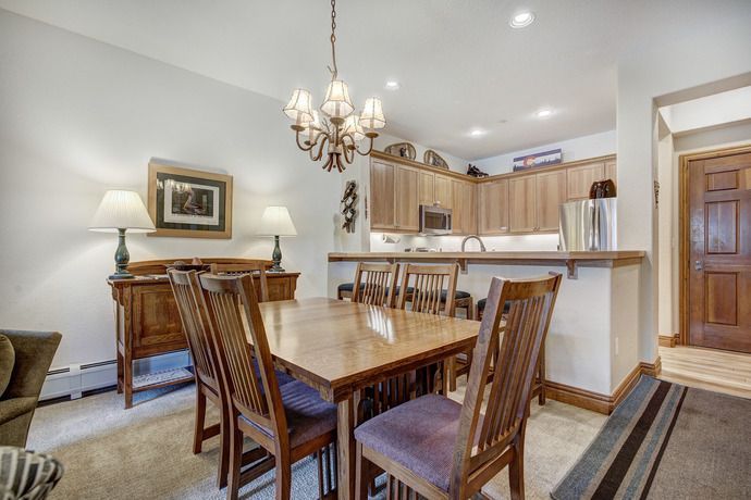 image Spacious dining area adorned with a charming chandelier, ideal for family meals and gatherings.