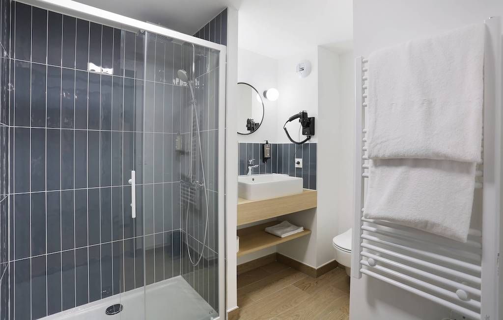 image Get ready in the bathroom with a towel rail and shower.