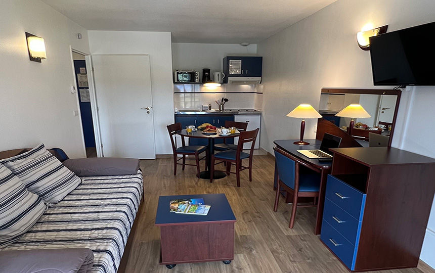 image Sit down to a meal at the dining table, with the kitchenette right beside the sofa.