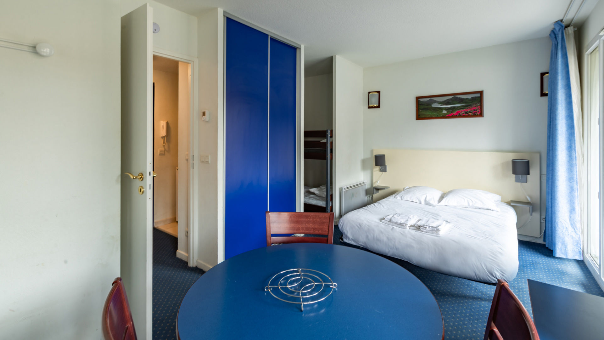image A double bed and a wardrobe with blue sliding doors make the main room a base for ski days.