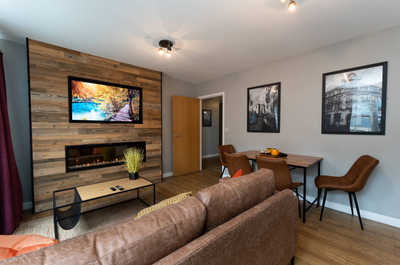 Beautiful living area with contemporary 60" fireplace and 50" smart TV