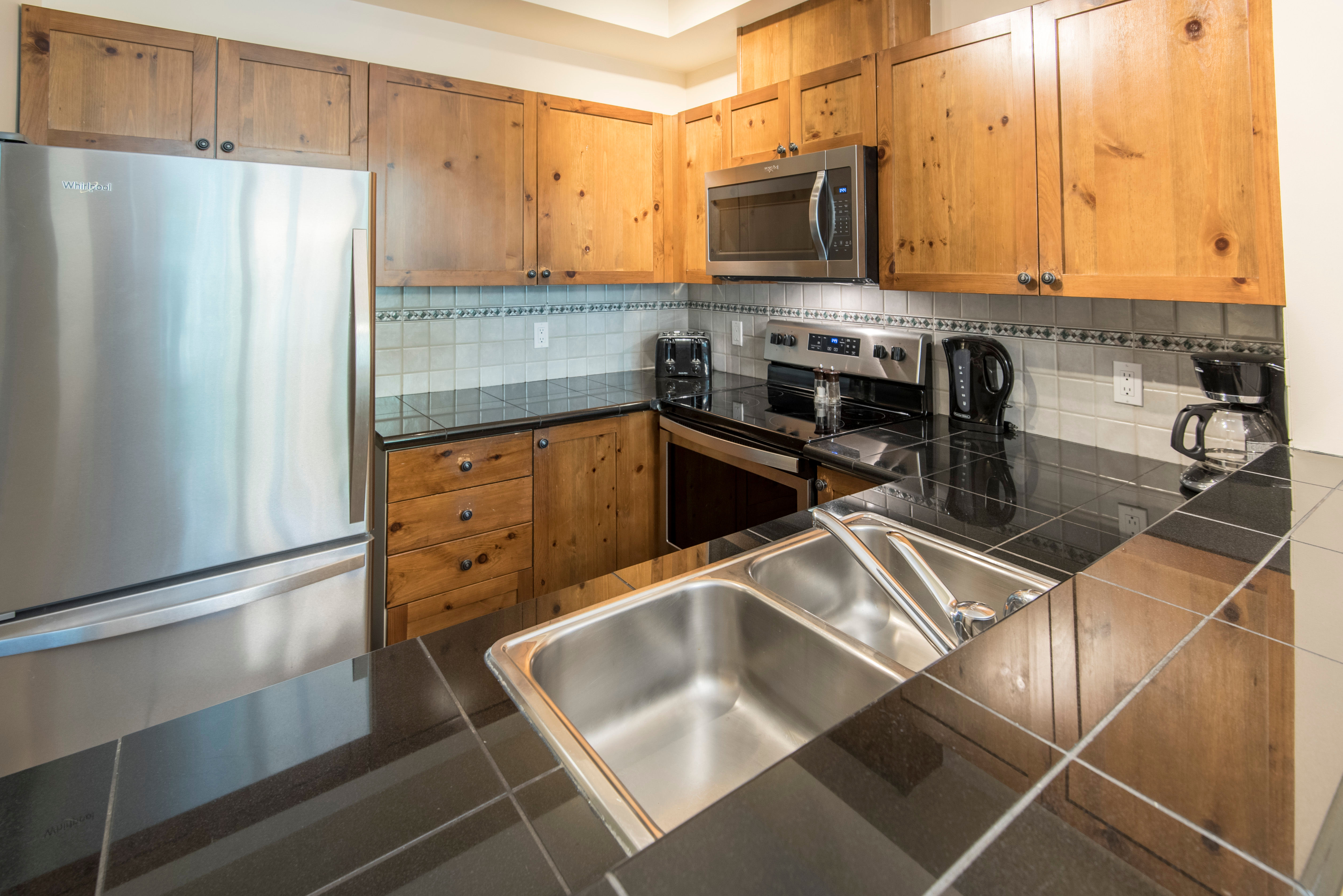 image The kitchen features a full sized fridge and freezer and an oven