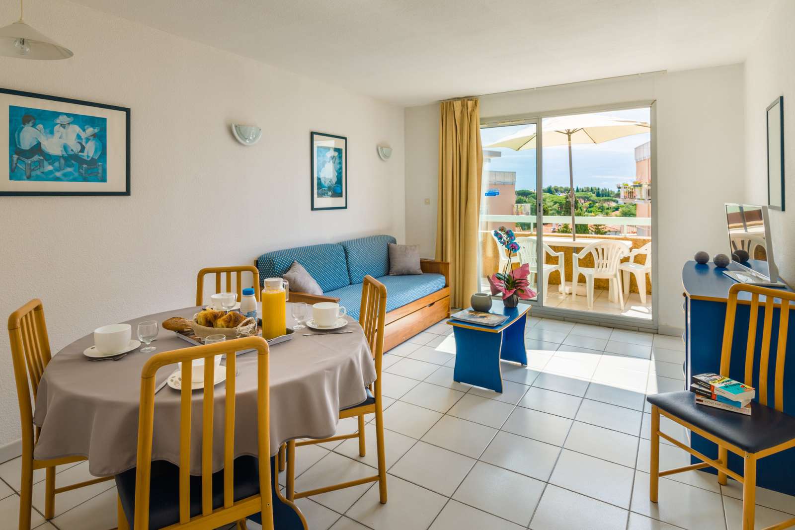 image Enjoy a cozy meal in this inviting living and dining area, featuring a comfortable sofa and easy access to the balcony.