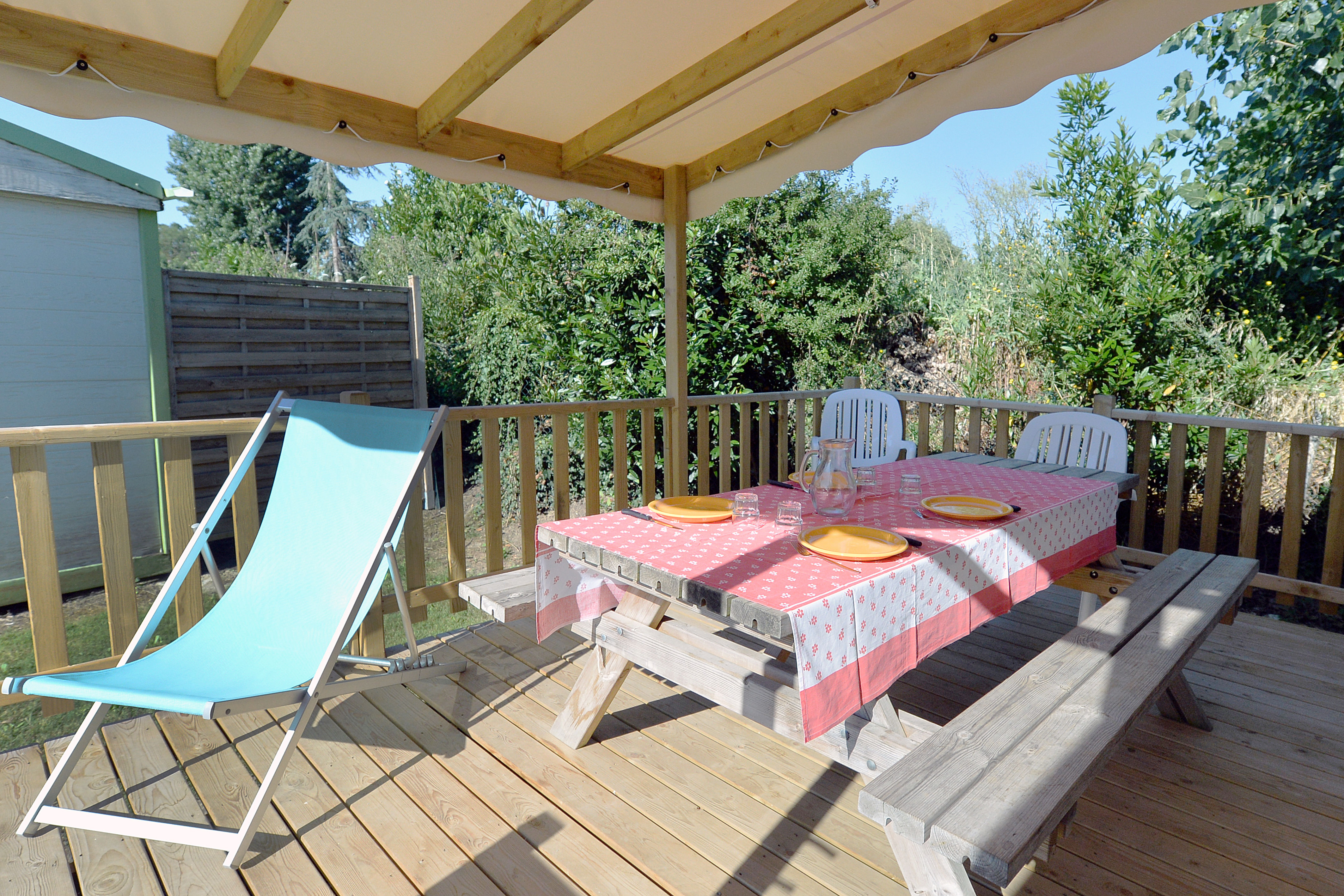 image Enjoy the fresh air on the covered deck, where comfortable loungers and a picnic table invite you to unwind.