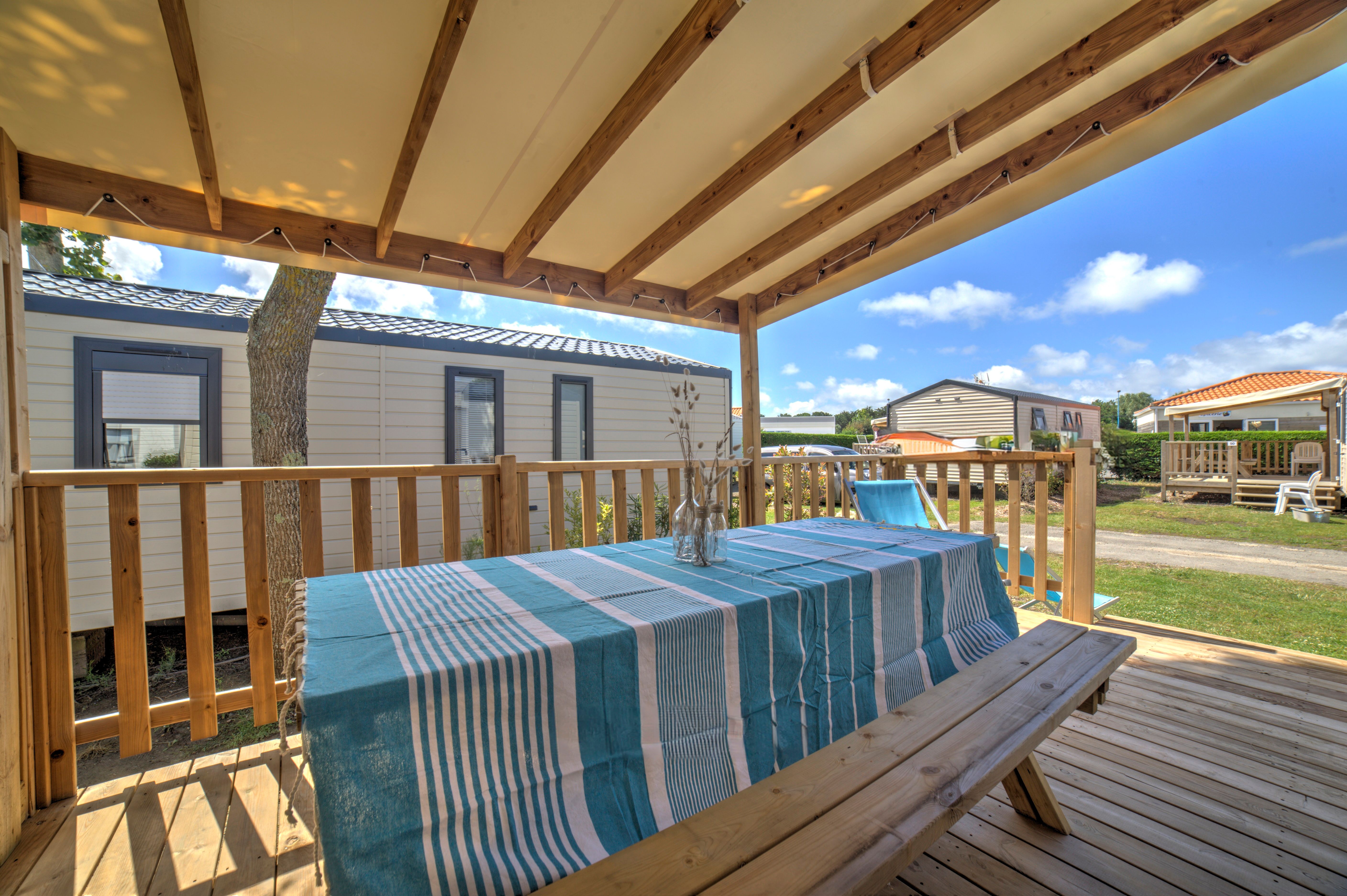 image Relax on the covered deck, where a picnic-style table invites open-air dining with views of the lush surroundings.