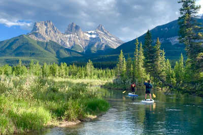  Glide across Canmore's crystal-clear waters with the stunning Rockies towering in the distance—pure bliss on a paddleboard.