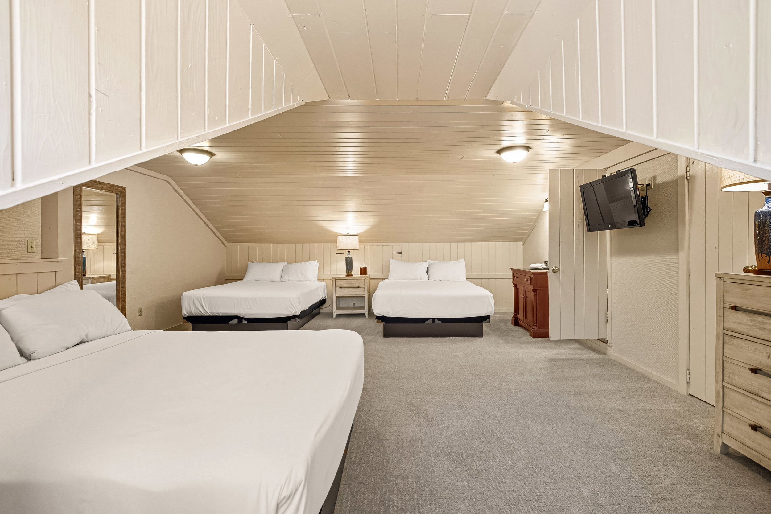 image This spacious bedroom offers multiple beds and comfortable furnishings, making it suitable for family or friends sharing a night together.