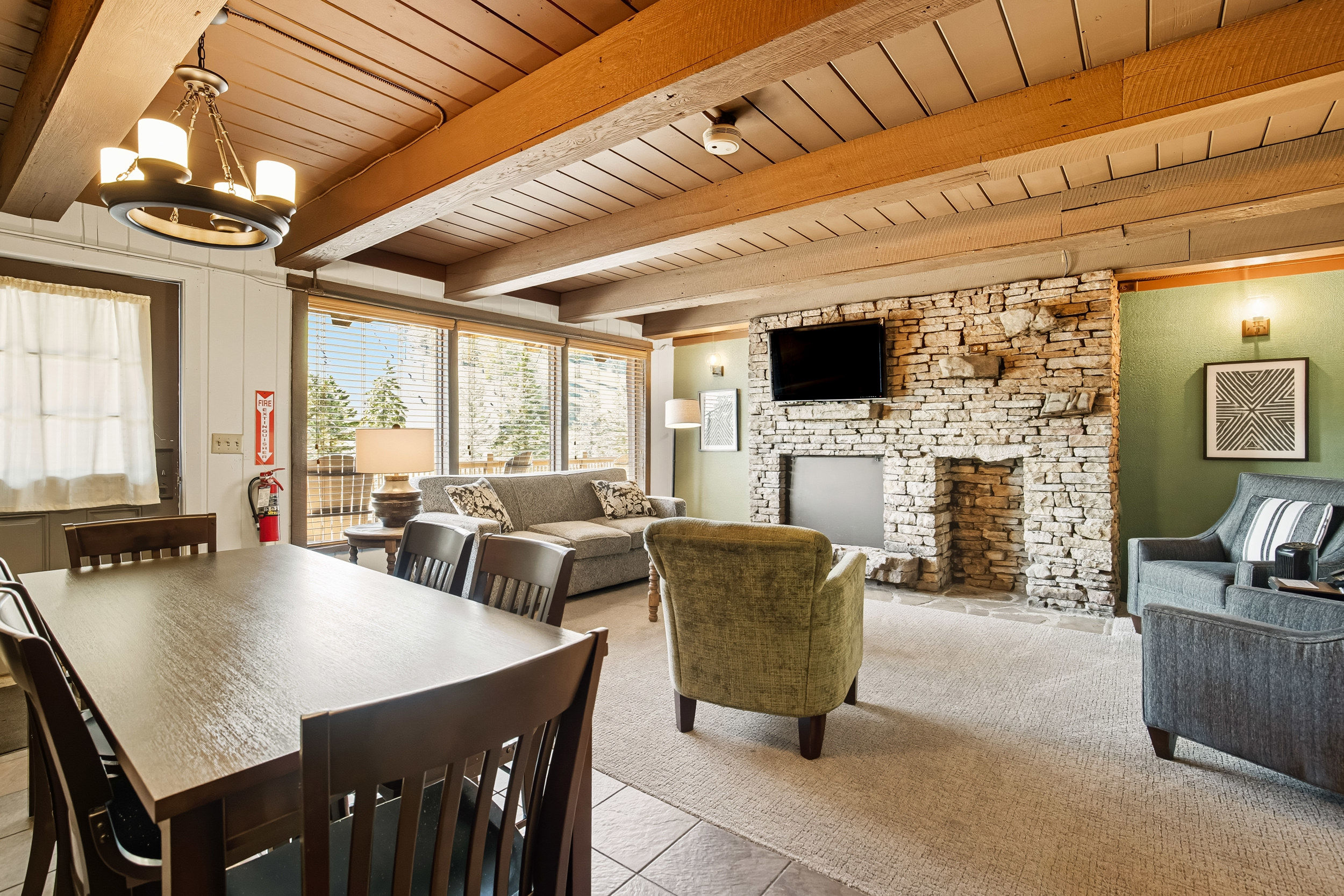 image Large windows in the cozy living space provide breathtaking views of the mountains, making it a perfect retreat for families to relax together.