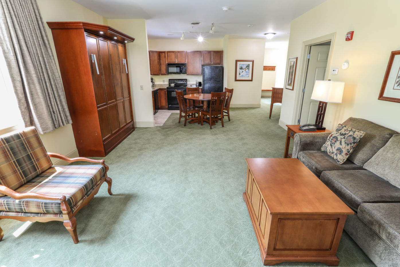 image Spacious and cozy living area with warm lighting and a seamless flow into the dining and kitchen space.