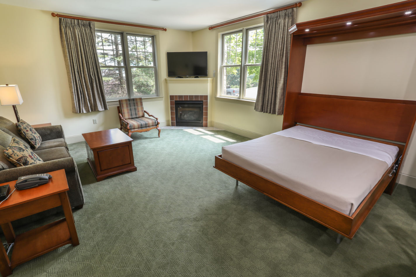 image Inviting bedroom with a fireplace and large windows, creating a relaxing atmosphere for a peaceful stay.