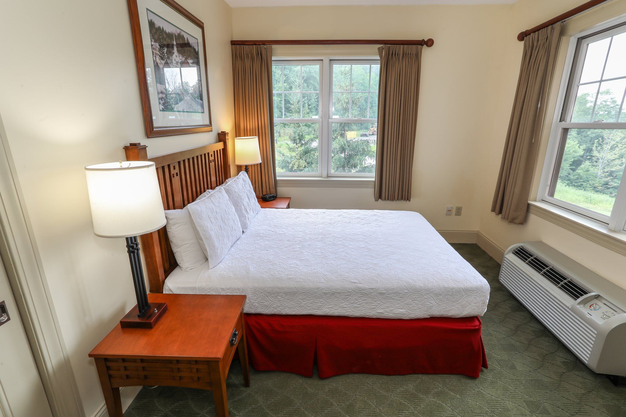 image Comfortable bedroom with a spacious bed and large windows offering natural light.