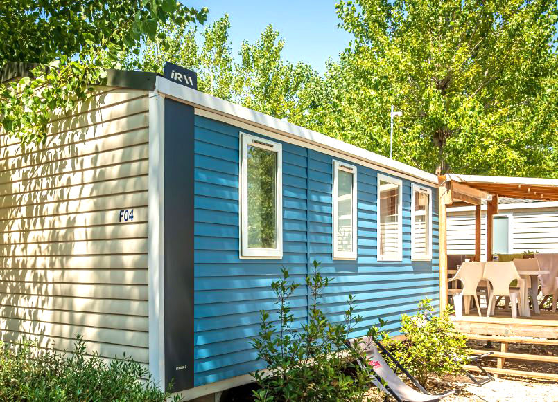 image Charming mobile home with a vibrant blue exterior, perfect for a peaceful getaway.