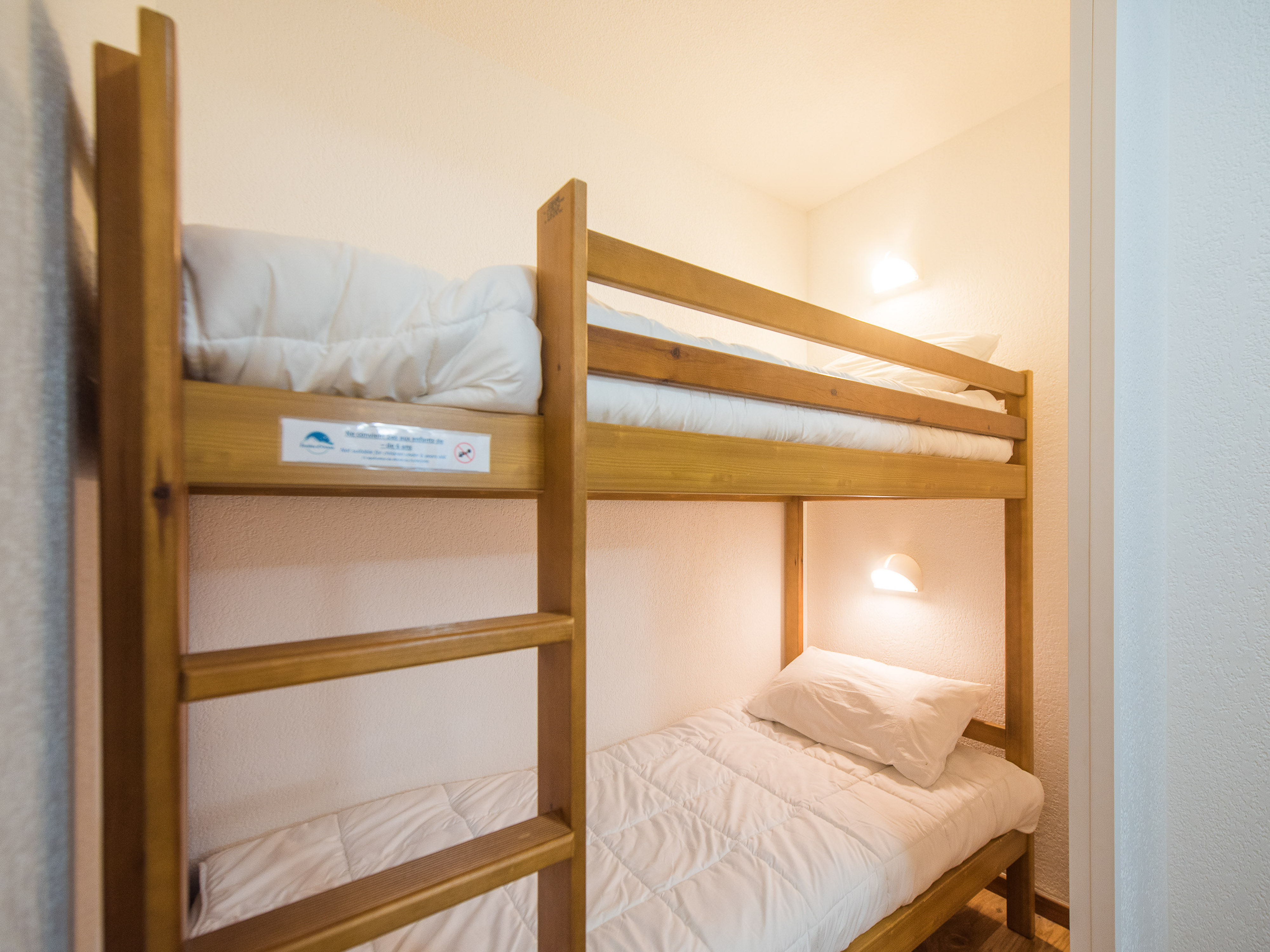 image Discover a compact and cozy space in our sleeping alcove, complete with a comfortable bunk bed perfect for a restful sleep.