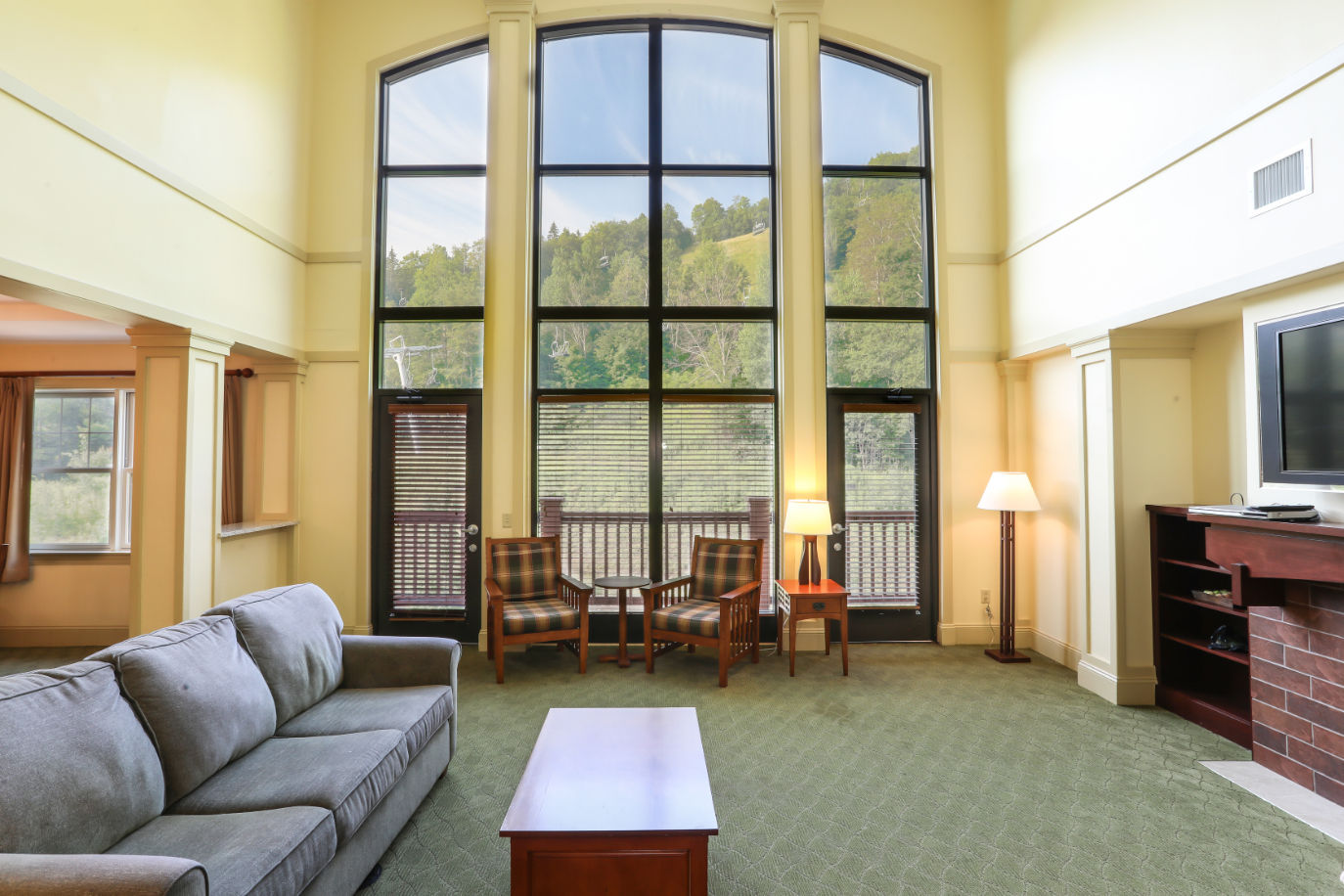 image Sunlit living space with soaring windows and stunning views, perfect for relaxation and unwinding.