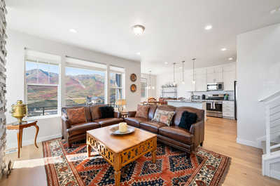 The spacious living area offers a breathtaking overlook of scenic mountain views through large windows.