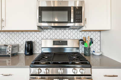 Geometric tiles frame state-of-the-art appliances, while everyday essentials stand ready for culinary magic.