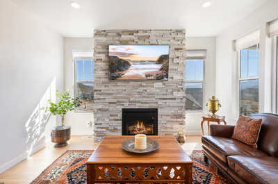 Relax by the fireplace, in this sunlit living space. 