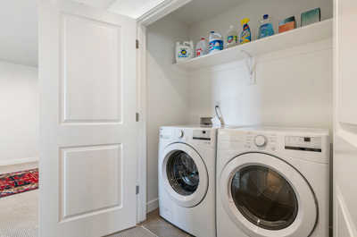 A laundry space is available behind the closet next to the loft area upstairs. It features modern LG appliances and cleaning products.