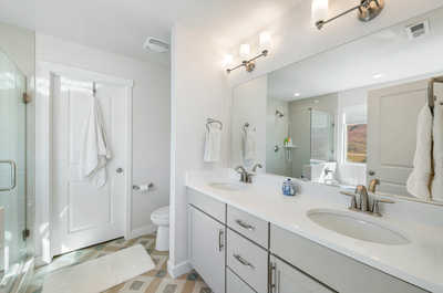 Contemporary bathroom elegance, featuring a dual-sink vanity, glass-enclosed shower, and a breathtaking window panorama showcasing nature's splendor.